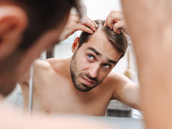 implante capilar - hombre revisando su pelo
