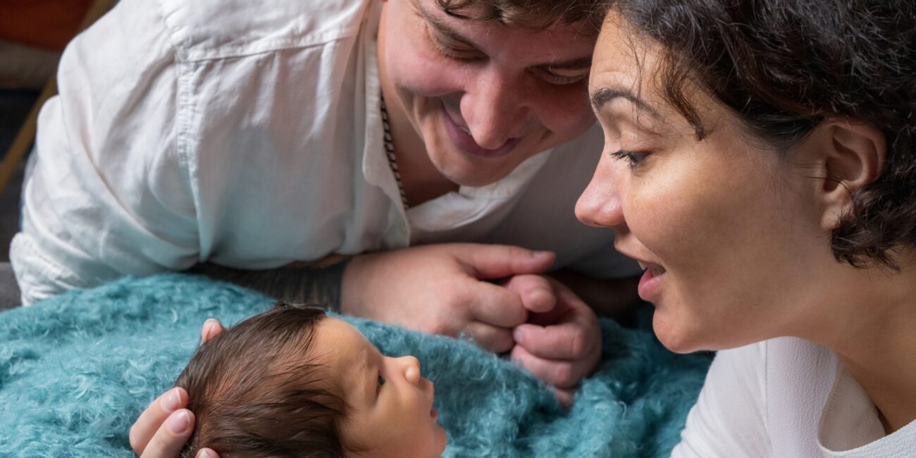 Parents holding newborn after surrogacy in the US in hospital setting