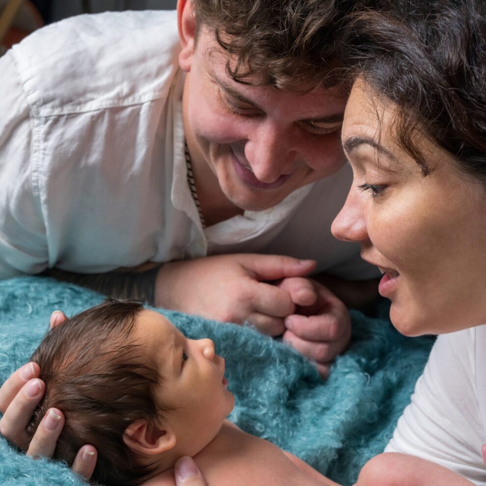 Parents holding newborn after surrogacy in the US in hospital setting